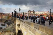 Thumbnail image of tourists walk on the Charles Bridge under a stormy sky, Prague, Czech Republic